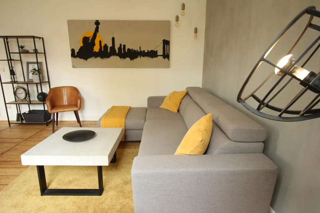 Wohnzimmer des NY Loft mit Ecksofa und Skyline-Bild